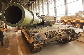 Detailed view of a military tank inside a museum, emphasizing the large barrel and robust design. HD wallpaper