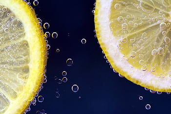 Close-up of lemon slices with bubbles, capturing freshness and vibrancy. HD wallpaper