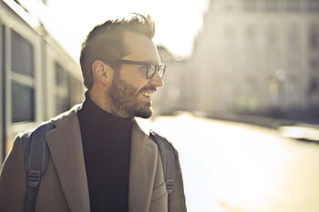 Smiling man with glasses and coat enjoying a sunny day in Budapest. HD wallpaper