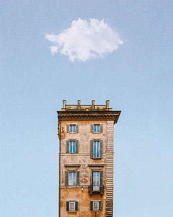 A striking view of an ancient building with architectural details under a solitary cloud in a blue sky. HD phone wallpaper