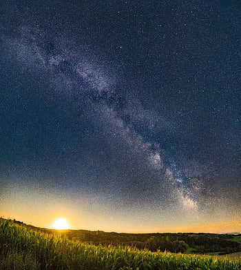 Captivating view of the Milky Way galaxy with a sunset over a serene green field. HD phone wallpaper