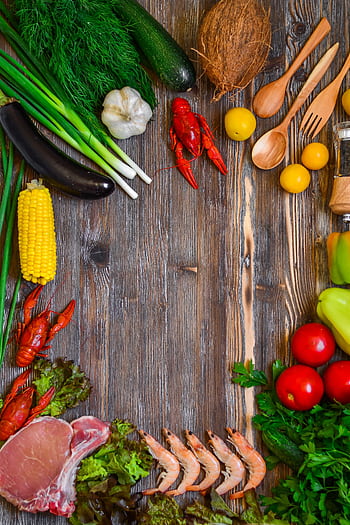 Colorful fresh ingredients including vegetables, seafood, and herbs arranged on a rustic wooden table. HD phone wallpaper