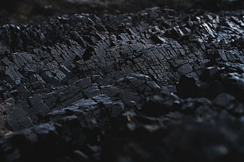 A detailed close-up of dark charcoal texture, showcasing its rough and jagged surface. HD wallpaper