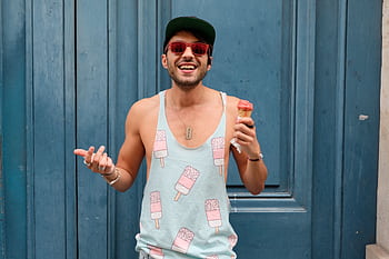 Happy man in Paris enjoying ice cream against a blue door. Fashionable and fun summer vibe. HD wallpaper