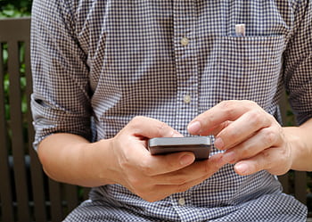 Close-up of a man using a smart, focusing on hands and modern technology. HD wallpaper