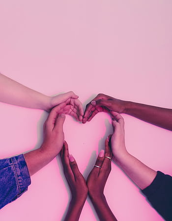 A group of diverse hands forming a heart shape against a soft pink background, symbolizing love and unity. HD phone wallpaper