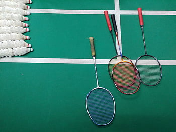 Top view of badminton rackets and shuttlecocks on an indoor court. HD wallpaper