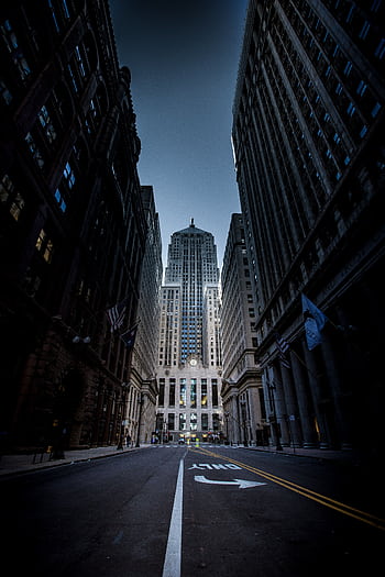 Majestic view of Chicago skyscrapers along an empty street at dusk, showcasing urban architecture. HD phone wallpaper