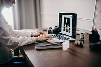 A lancer working on a laptop in a cozy home office, focusing on creative design tasks. HD wallpaper