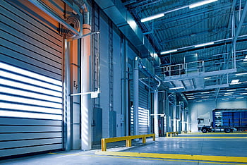 Spacious and modern warehouse interior with parked truck and steel structures. HD wallpaper