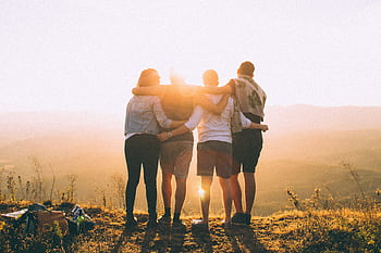 A group of friends embrace while enjoying a breathtaking sunrise over the Brazilian highlands. HD wallpaper