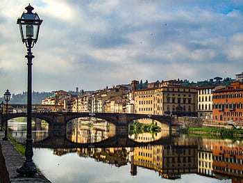 A breathtaking view of Florence's architecture reflecting in the river at dusk, capturing the vibrant essence of Italy. HD wallpaper
