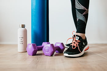 A fitness setup featuring a water bottle, dumbbells, and sneakers for an inspiring home workout. HD wallpaper