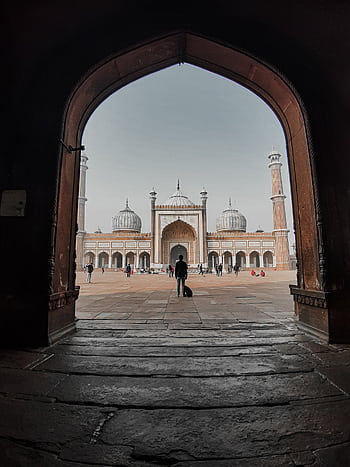 A stunning view of Jama Masjid Mosque in Delhi captured through an arched doorway. HD phone wallpaper