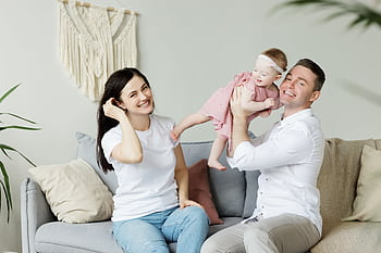 Loving parents playing with their baby daughter at home, capturing moments of joy and togetherness indoors. HD wallpaper