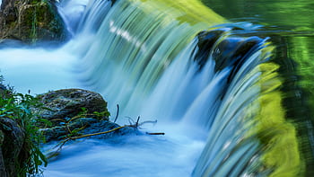 A serene waterfall cascading over mossy rocks in Munich, Germany. HD wallpaper