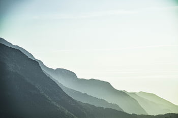 A serene view of misty mountain layers in Schwaz, Tirol, Austria at dawn. HD wallpaper