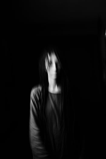 Haunting blurred portrait of a woman on a dark background, creating a ghostly effect. HD phone wallpaper
