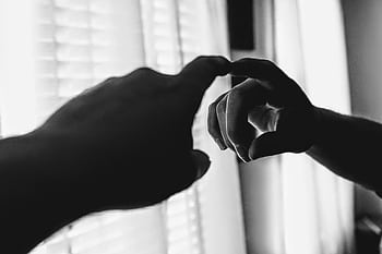 A dramatic black and white of a hand reaching toward a mirror, creating a reflective illusion. HD wallpaper