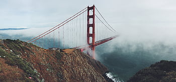 A stunning view of the Golden Gate Bridge partially shrouded in mist, connecting San Francisco's serene landscapes. HD wallpaper