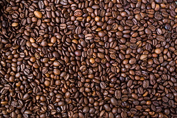 A detailed view of medium roast coffee beans, rich in texture and color. HD wallpaper