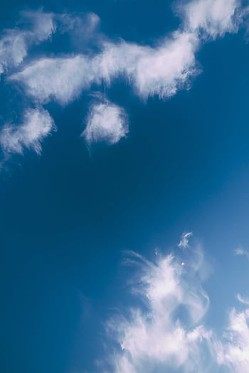 Blue sky full of fluffy white clouds, capturing a serene and peaceful atmosphere. HD phone wallpaper
