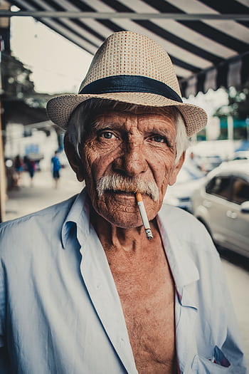 Portrait of an elderly man wearing a hat and smoking in São Paulo's streets, Brazil. HD phone wallpaper