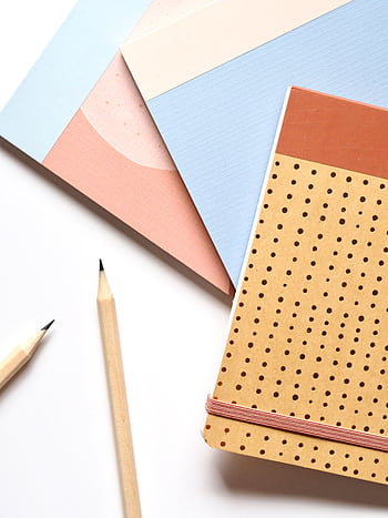 Colorful notebooks and pencils arranged neatly for a creative workspace. HD phone wallpaper