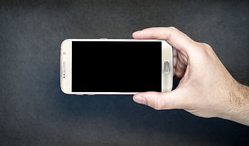 Close-up of a hand holding a smart with a blank screen, ready for design mockup. HD wallpaper