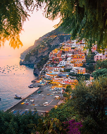 Breathtaking view of Positano's colorful cliffside homes at sunset. HD phone wallpaper
