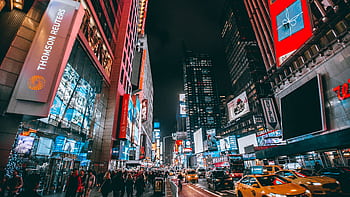 Bustling evening scene in New York City's iconic Times Square, showcasing bright lights and lively atmosphere. HD wallpaper