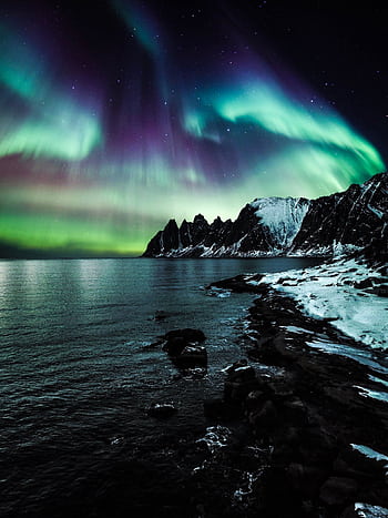 Majestic northern lights illuminate the snow-covered coast of Lenvik, Troms, Norway. HD phone wallpaper