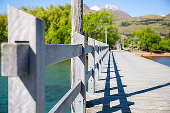 Explore the beauty of a wooden bridge with mountain views and vibrant greenery in Queenstown, New Zealand. HD wallpaper