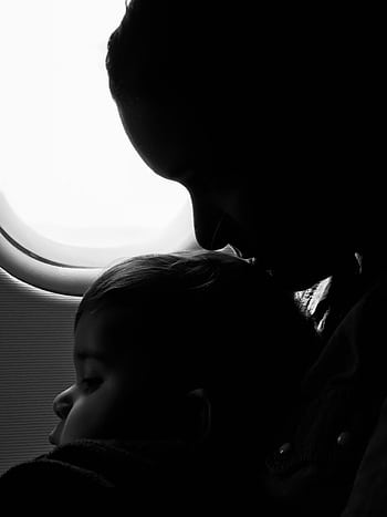 Silhouette of a mother and child gazing out an airplane window during flight. HD phone wallpaper