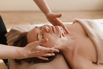 Woman receiving a soothing facial massage, promoting relaxation and wellness. HD wallpaper