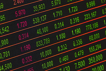 Close-up of a digital stock market data display showing colorful financial numbers and trends. HD wallpaper