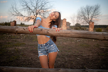 Cowgirl resting, cowgirl, fence, brunette, shorts, field HD wallpaper