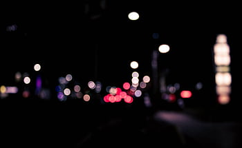 Blurred urban nighttime scene with colorful bokeh lights creating a dreamy effect. HD wallpaper