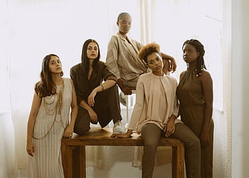 Five diverse women in fashionable outfits representing empowerment and unity. HD wallpaper