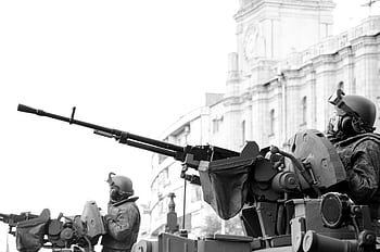 Monochrome of soldiers in armored tanks, equipped with rifles, patrolling urban surroundings. HD wallpaper