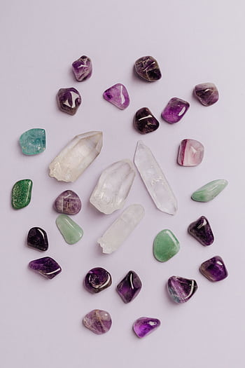 A variety of polished gemstones in vibrant colors arranged on a white surface. HD phone wallpaper
