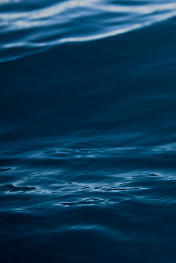 A tranquil view of dark blue ocean waves with gentle ripples and motion. HD phone wallpaper