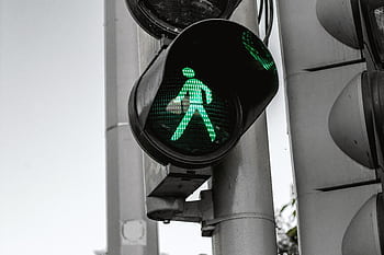 Close-up of a green pedestrian traffic signal indicating walk at an intersection. HD wallpaper