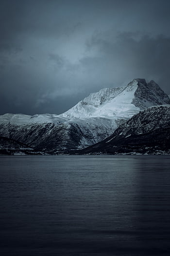 Experience the tranquil beauty of a snow-covered mountain in Norway, captured during twilight. HD phone wallpaper