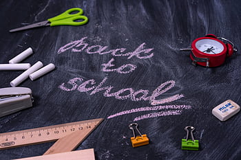 An arrangement of school supplies with 'back to school' written on a chalkboard. HD wallpaper