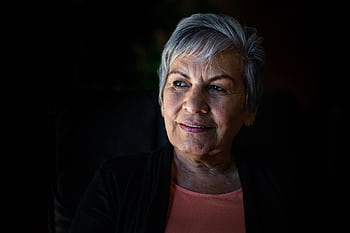 Elderly woman with gray hair looking thoughtfully, showcasing wisdom and grace. HD wallpaper