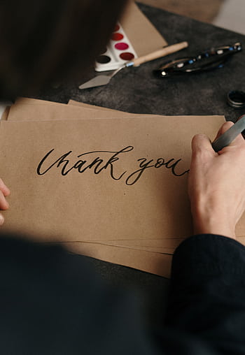 Person writing a 'Thank You' card with calligraphy. Perfect for gratitude expressions. HD phone wallpaper