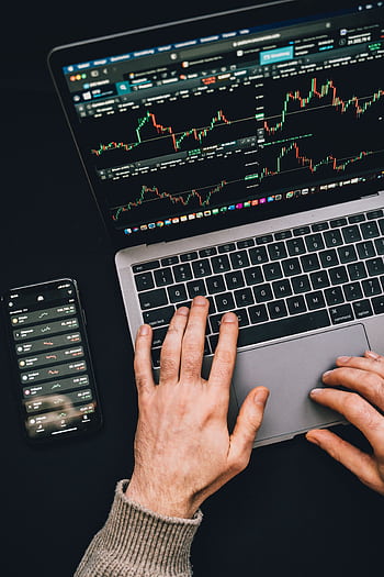 Hands typing on a laptop with cryptocurrency charts and smart display in view, focusing on digital finance. HD phone wallpaper