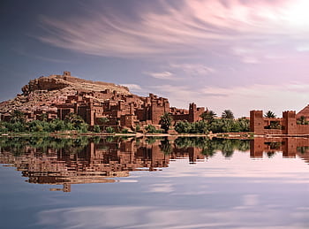 que reflection of Ouarzazate's historic ksar by the river under a vibrant sky. HD wallpaper