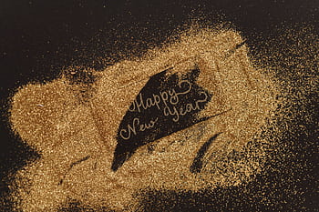 A festive greeting with glitter and cursive lettering spelling 'Happy New Year'. Perfect for seasonal celebrations. HD wallpaper